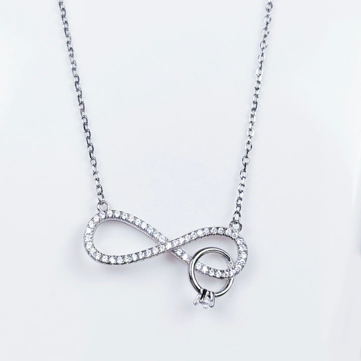 Silver ring in infinity pendant